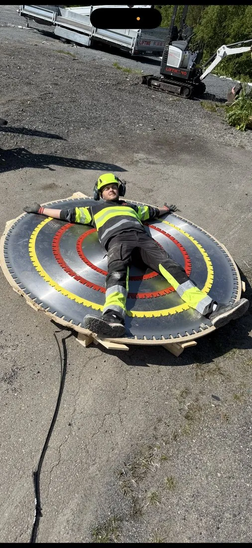 Mann ligger på stort sagblad